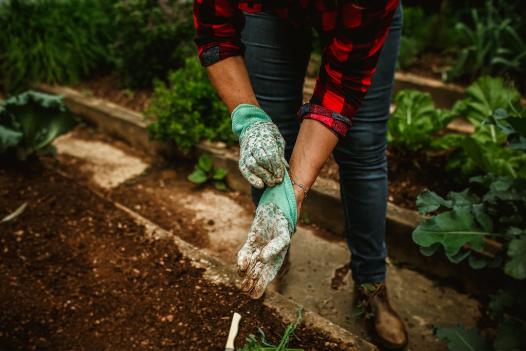 A woman in gardening gloves holding a shovel