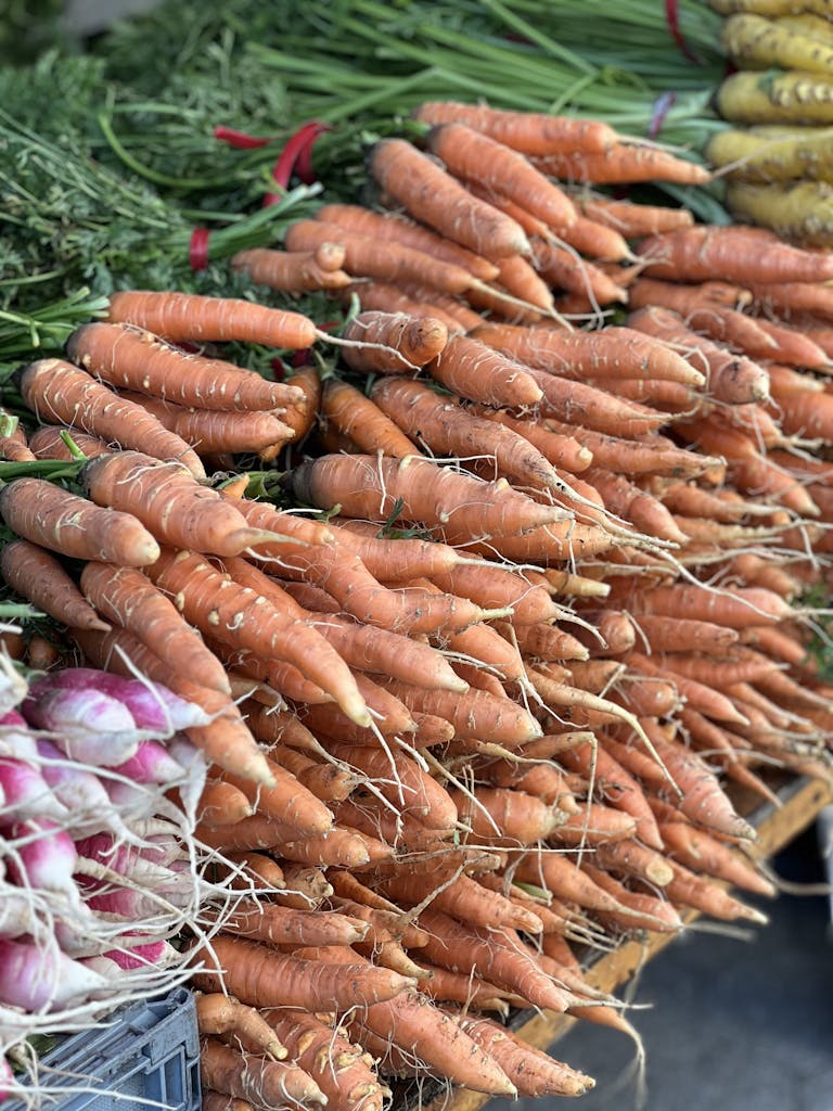 Carrots and onions are displayed at a farmers market